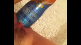 граючи пляшкою з кремом для засмаги